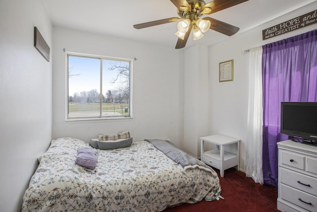 bedroom with ceiling fan and dark colored carpet