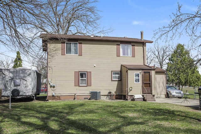 rear view of property with entry steps and a lawn