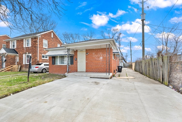 11726 Payton St, Detroit, MI 48224 - view of front facade with a front yard, brick siding, driveway, and fence