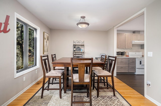dining area featuring baseboards and light wood-style floors