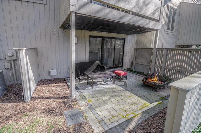 view of patio featuring an outdoor fire pit and fence