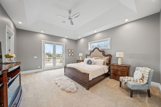 carpeted bedroom featuring multiple windows, access to exterior, baseboards, and a raised ceiling