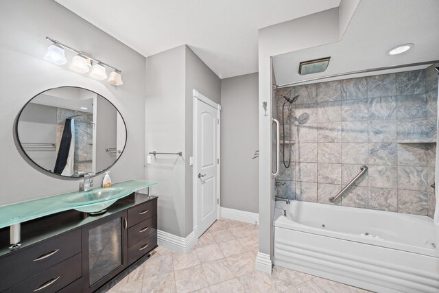 full bath featuring a combined bath / shower with jetted tub, vanity, and baseboards
