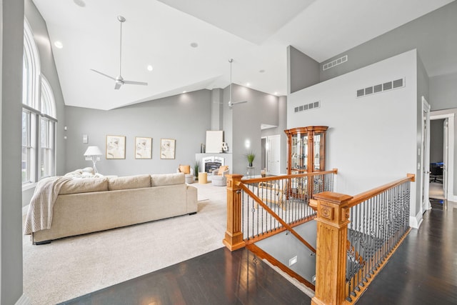 living area with wood finished floors, a ceiling fan, and visible vents