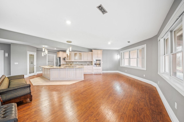 living room with light wood-style flooring, baseboards, visible vents, and recessed lighting