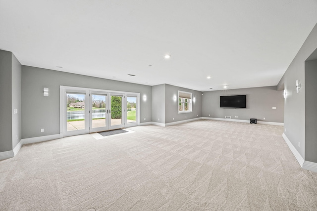 unfurnished living room featuring baseboards, recessed lighting, and light carpet