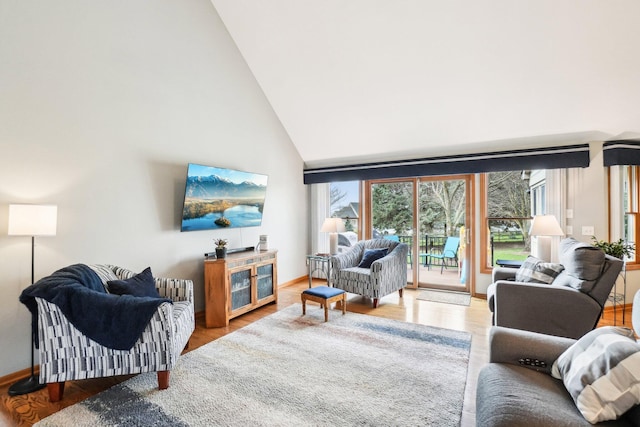 living room with high vaulted ceiling, baseboards, and wood finished floors