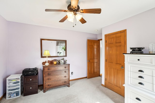 bedroom with light colored carpet, baseboards, and a ceiling fan