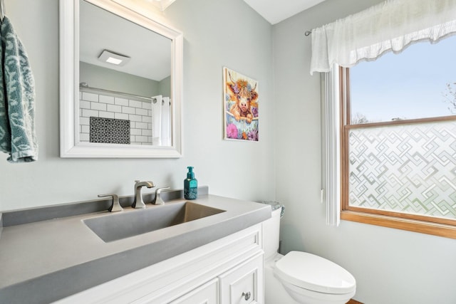 bathroom featuring a shower with shower curtain, vanity, and toilet