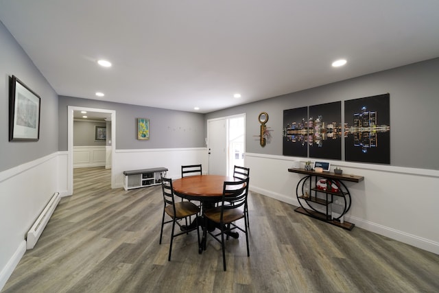 dining room with a wainscoted wall, recessed lighting, wood finished floors, and baseboard heating
