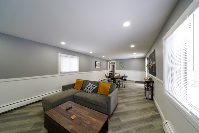 living room featuring a baseboard radiator, wood finished floors, baseboards, and recessed lighting