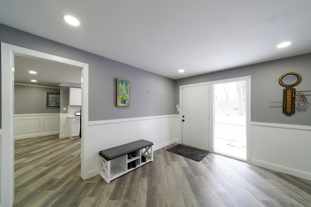 entryway with a decorative wall, recessed lighting, wainscoting, and wood finished floors