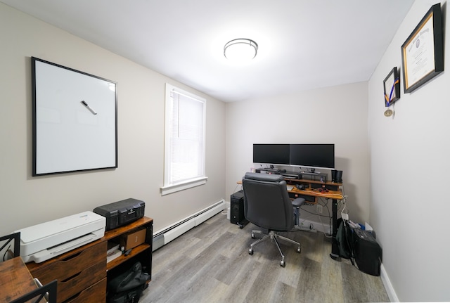 office space with baseboard heating, wood finished floors, and baseboards
