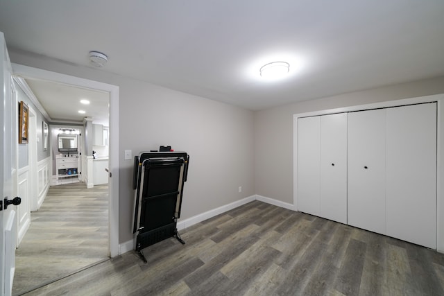 bedroom with a closet, baseboards, and wood finished floors