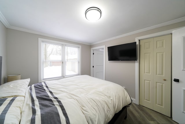 bedroom with a closet, crown molding, and dark wood finished floors