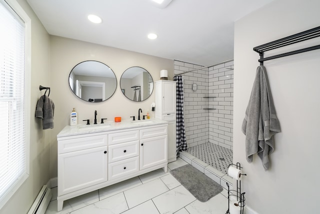bathroom featuring tiled shower, double vanity, baseboard heating, and a sink