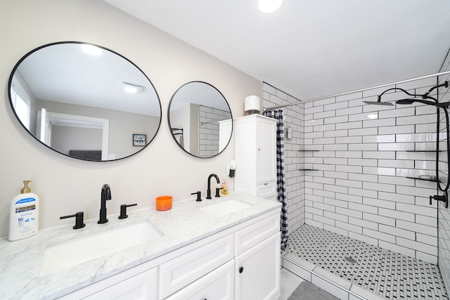 bathroom featuring a stall shower, double vanity, and a sink