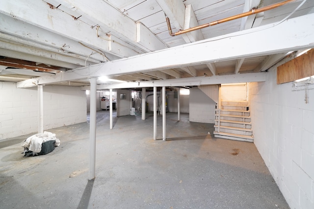 unfinished below grade area featuring stairs and concrete block wall