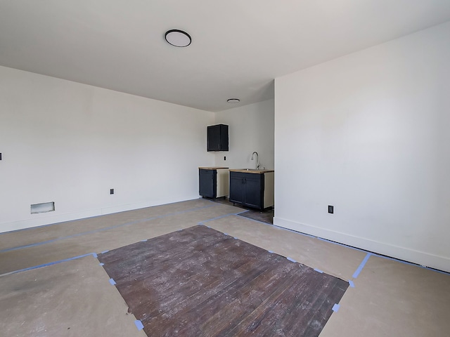 11765 Glenfield St, Detroit, MI 48213 - unfurnished living room with a sink, baseboards, indoor wet bar, and unfinished concrete floors