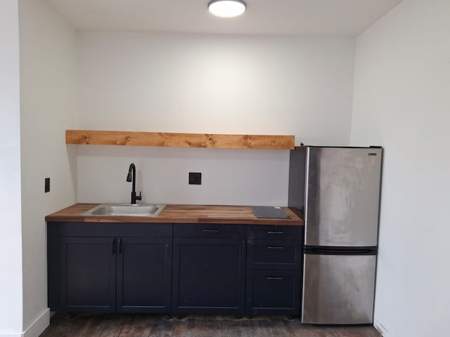 11765 Glenfield St, Detroit, MI 48213 - kitchen with freestanding refrigerator, butcher block counters, wood finished floors, a sink, and baseboards
