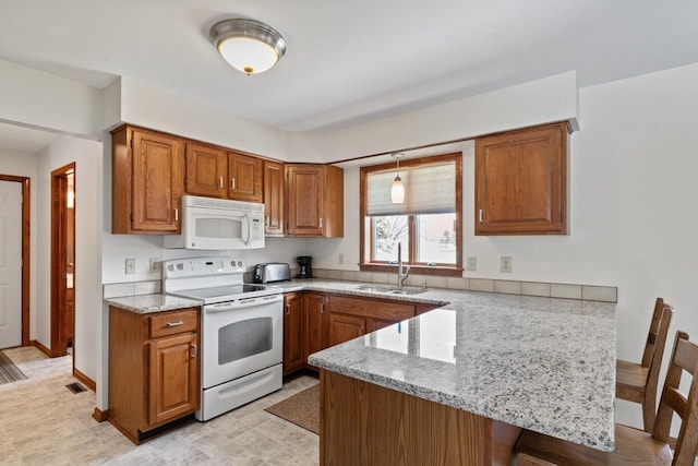 5802 Pratt Rd, Lapeer, MI 48446 - kitchen featuring white appliances, a peninsula, brown cabinets, a breakfast bar area, and light stone countertops