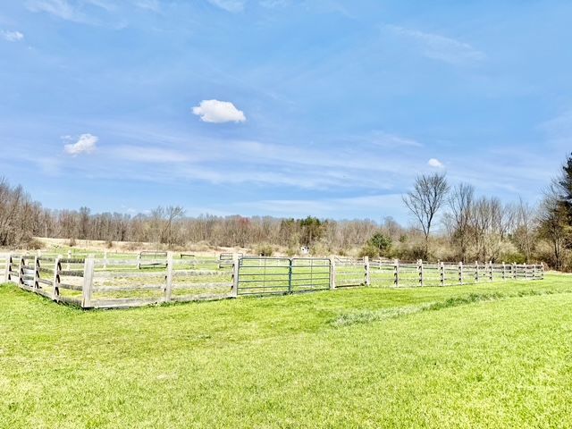view of yard featuring fence and a rural view