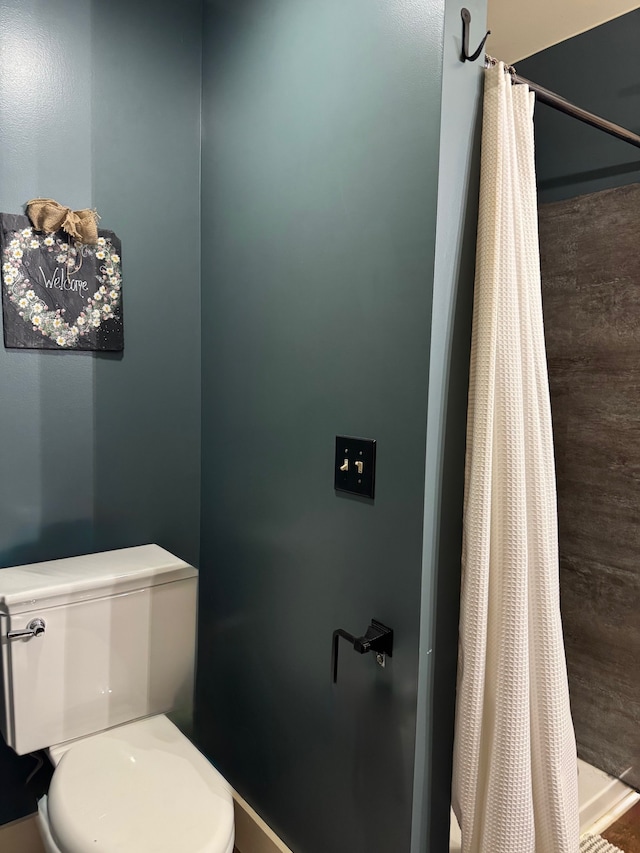bathroom featuring curtained shower and toilet