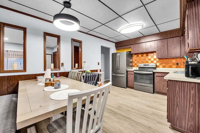 32334 Gloede Dr, Warren, MI 48088 - dining area with light wood finished floors, a drop ceiling, and wooden walls