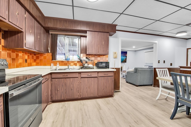 32334 Gloede Dr, Warren, MI 48088 - kitchen with black microwave, electric range, light wood-type flooring, light countertops, and backsplash