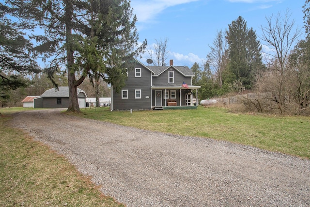 12934 Wilson Rd, Fruitport, MI 49415 - view of front of property with an outdoor structure, a chimney, driveway, a front lawn, and covered porch