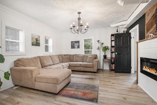 12934 Wilson Rd, Fruitport, MI 49415 - living room with light wood-style floors, a healthy amount of sunlight, a notable chandelier, and a textured ceiling