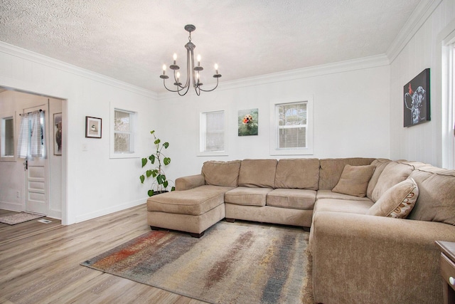 12934 Wilson Rd, Fruitport, MI 49415 - living room featuring a textured ceiling, wood finished floors, an inviting chandelier, and crown molding