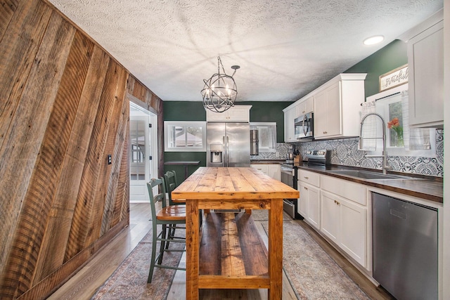 12934 Wilson Rd, Fruitport, MI 49415 - kitchen with white cabinets, a sink, dark wood-style floors, stainless steel appliances, and decorative backsplash