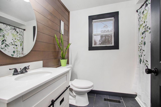 12934 Wilson Rd, Fruitport, MI 49415 - bathroom featuring vanity, visible vents, toilet, wood walls, and tile patterned floors