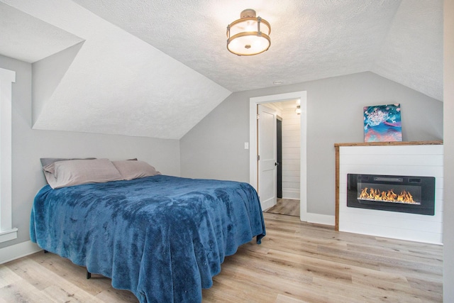 12934 Wilson Rd, Fruitport, MI 49415 - bedroom with a textured ceiling, wood finished floors, baseboards, and vaulted ceiling