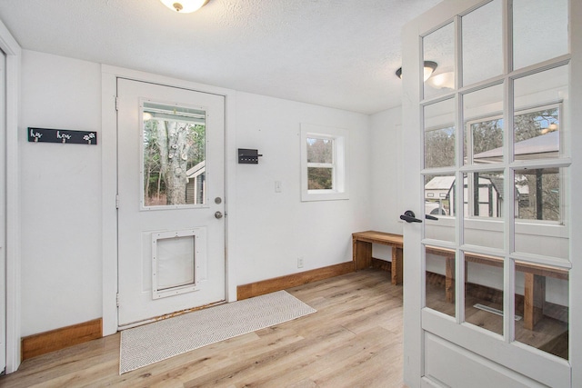 12934 Wilson Rd, Fruitport, MI 49415 - foyer entrance with light wood-type flooring, baseboards, and a textured ceiling