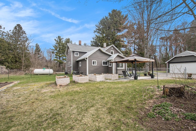 12934 Wilson Rd, Fruitport, MI 49415 - back of property with a patio, an outdoor structure, a garden, a yard, and fence