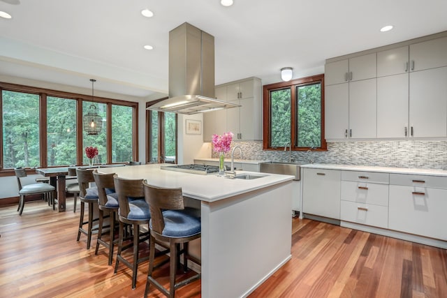 kitchen with island range hood, a sink, gray cabinetry, decorative backsplash, and recessed lighting