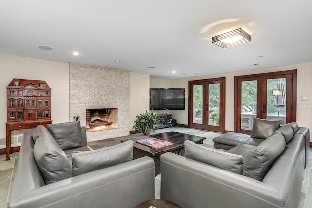 living room with french doors, a large fireplace, recessed lighting, and baseboards