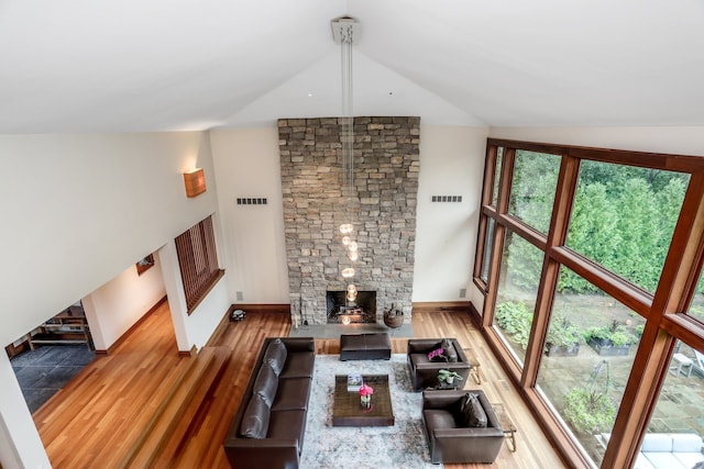 living area with vaulted ceiling, wood finished floors, and baseboards