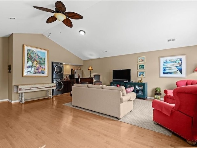 2011 W Lake Dr, Novi, MI 48377 - living area with stacked washing machine and dryer, a ceiling fan, baseboards, lofted ceiling, and light wood finished floors