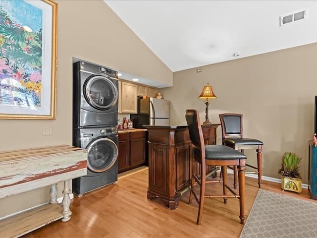 2011 W Lake Dr, Novi, MI 48377 - laundry room with estacked washer and dryer, light wood-type flooring, and baseboards