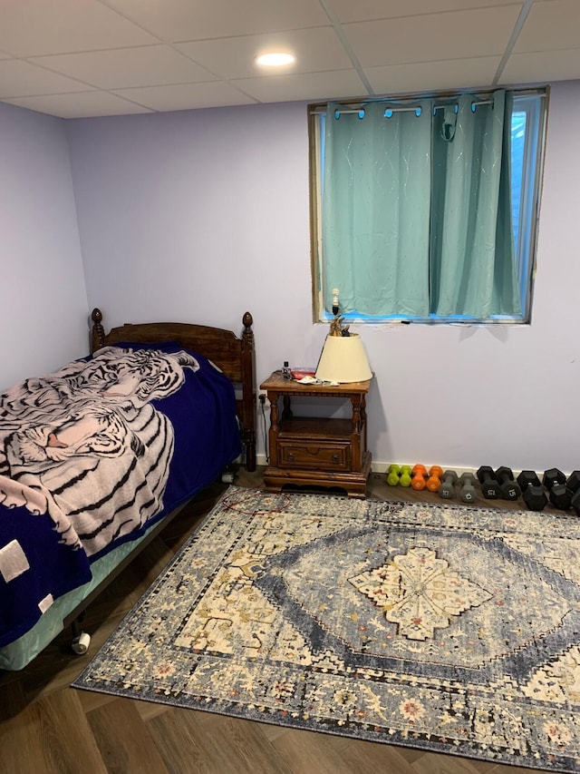 bedroom featuring wood finished floors and a drop ceiling