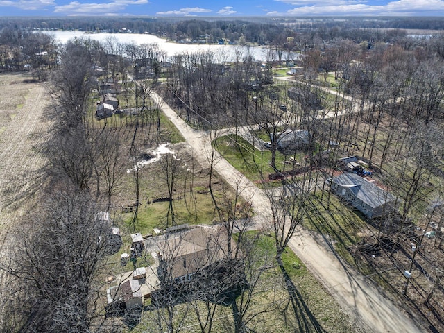 drone / aerial view featuring a wooded view and a water view
