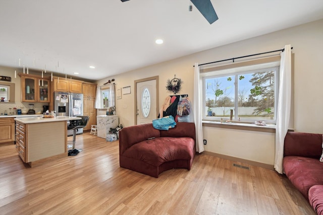 living area with light wood-style floors, baseboards, visible vents, and recessed lighting