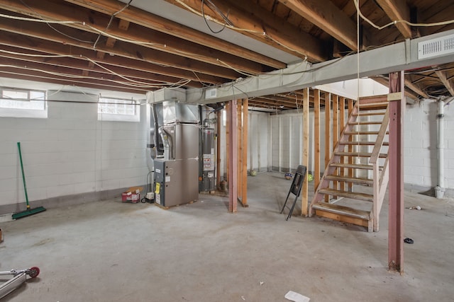 below grade area with stairs, water heater, visible vents, and heating unit