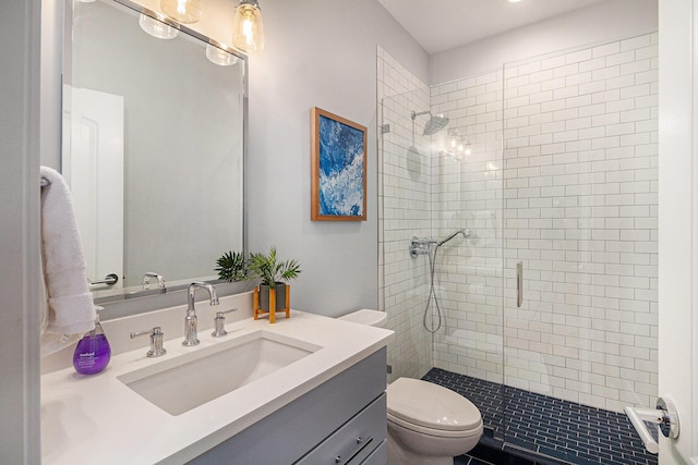 bathroom with a shower stall, vanity, and toilet