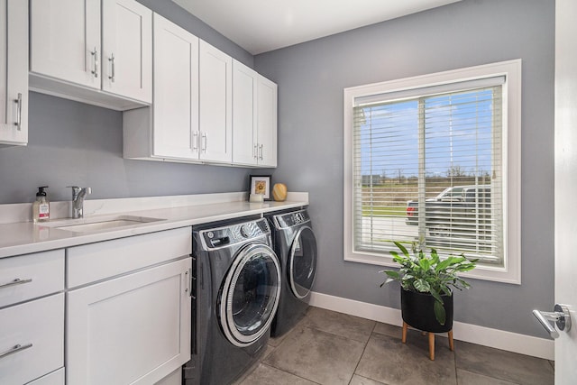 laundry area with baseboards, a sink, independent washer and dryer, cabinet space, and tile patterned floors