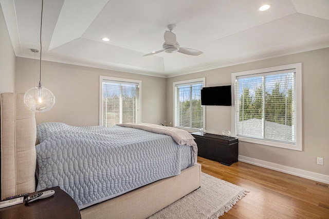 bedroom with light wood-type flooring, baseboards, recessed lighting, a ceiling fan, and a raised ceiling