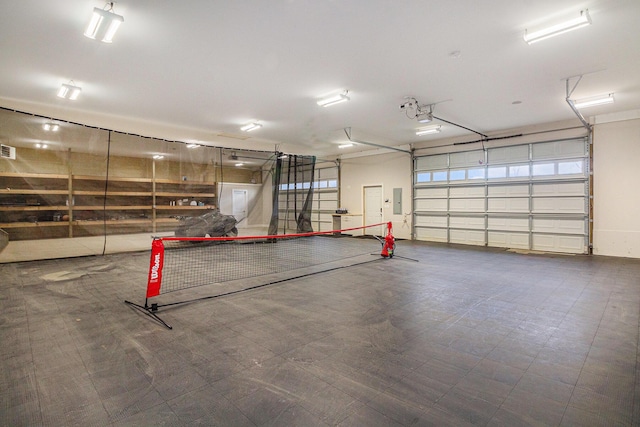 garage with electric panel, visible vents, and a garage door opener